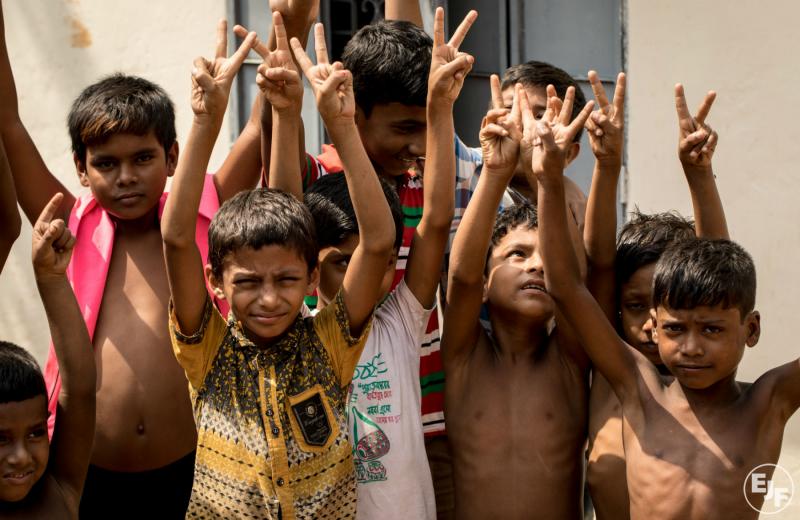 Boys in Bangladesh wave for the camera